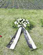 Feierliches Umbettungszeremoniell: Die Überreste deutscher Toter werden auf dem deutschen Soldatenfriedhof in Bartossen beigesetzt. Die LO stiftete einen Kranz (re).